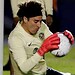 Portero de fútbol entrenando con balón en el arco, en una cancha profesional.