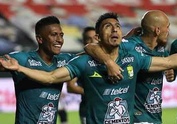 Jugadores de fútbol celebrando en el campo durante un partido en estadio mexicano.