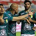 Jugadores de fútbol celebrando en el campo durante un partido en estadio mexicano.