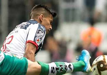 Atleta de fútbol en acción, disparando al arco en un partido competitivo en México.