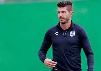 Jugador de fútbol profesional con uniforme deportivo, enfocado en el campo de juego.
