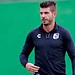 Jugador de fútbol profesional con uniforme deportivo, enfocado en el campo de juego.