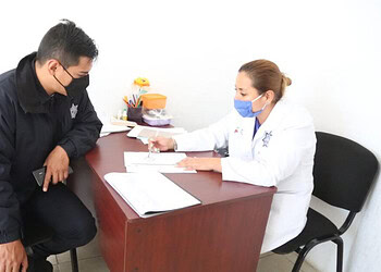 Atención médica con policías en consulta en oficina de clínica.