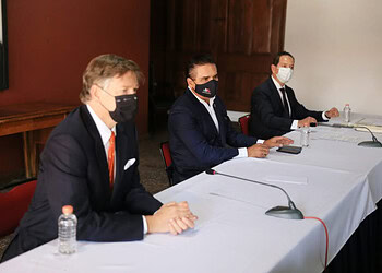 Eficaz reunión formal de empresarios y funcionarios en conferencia en interiores con cubrebocas.
