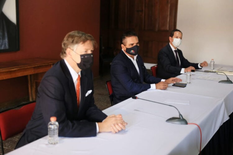 Eficaz reunión formal de empresarios y funcionarios en conferencia en interiores con cubrebocas.