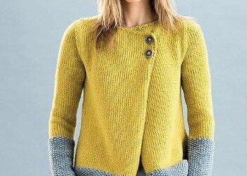 Mujer con suéter color mostaza y detalles gris, moda casual en tendencia 2023.