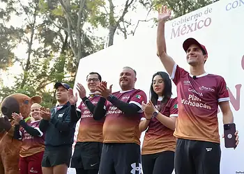 Corazón de México en un evento deportivo con participantes y mascota en celebración.