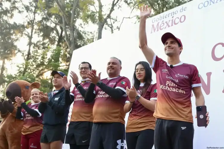 Corazón de México en un evento deportivo con participantes y mascota en celebración.