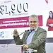 1. Hombre hablando en conferencia con pantalla de fondos de becas en segundo plano.