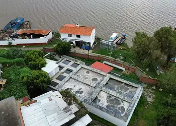 Contaminación de aguas residuales en planta de tratamiento junto a río en México.