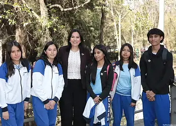 Estudiantes y profesora de escuela en parque, grupo escolar, educación, ambiente natural, camaradería, alumnos con uniforme, día soleado.
