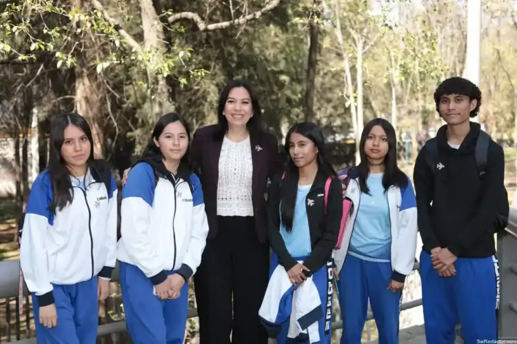Estudiantes y profesora de escuela en parque, grupo escolar, educación, ambiente natural, camaradería, alumnos con uniforme, día soleado.