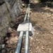 Tuberías de agua en obra de calle pavimentada con tubería de concreto y accesorios de acero galvanizado.