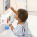 Niño en hospital usando monitor médico para diagnóstico.