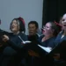 Coral de cantantes femeninas en un concierto en vivo, mostrando pasión y emoción.