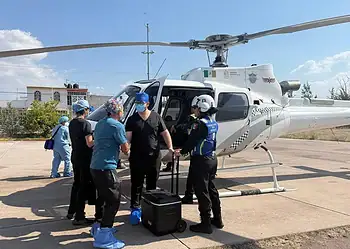 Personal de salud y emergencia abordo de un helicóptero en helipuerto.