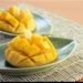 Jugosidad de mango fresco cortado en cubos en platos verdes, para postres y meriendas saludables.