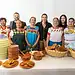 Personas celebrando con comida tradicional mexicana en evento cultural.