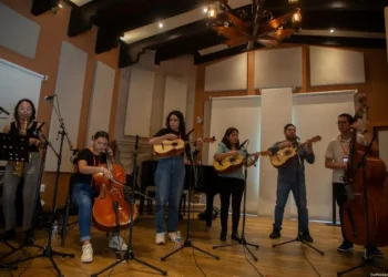 Artes musical en estudio con instrumentos de cuerda y viento en ambiente de grabación.