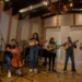 Artes musical en estudio con instrumentos de cuerda y viento en ambiente de grabación.