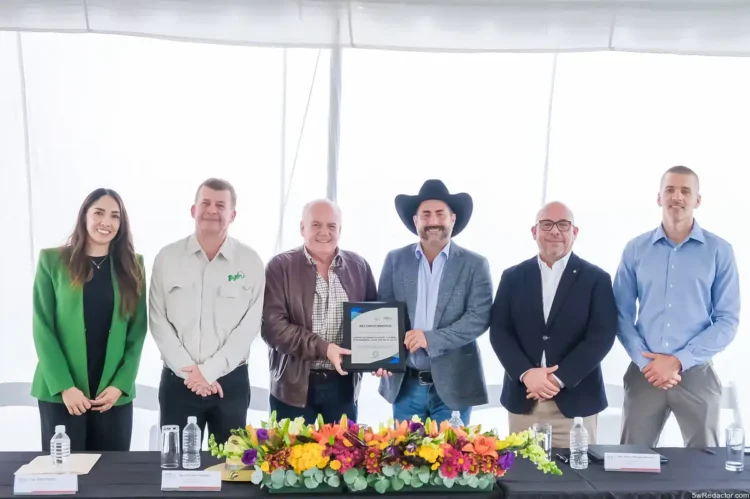 Reconocimiento empresarial presentado en evento formal con ejecutivos y un representante con sombrero cowboy.