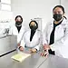 Personal de laboratorio femenino con batas y mascarillas en un entorno científico en México.