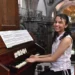 Pianista joven tocando en iglesia histórica durante evento cultural en Michoacán.