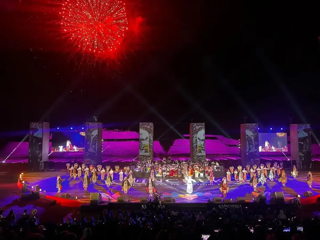 Espectáculo de fuegos artificiales y danza en la K’uínchekua 2026 en un escenario grande y colorido.