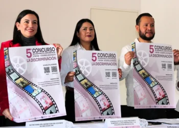 La imagen muestra personas participando en una campaña contra la discriminación, sosteniendo cartele.