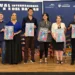Boca de la imagen con personas sosteniendo carteles en un evento cultural internacional.