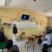 Aprendizaje en aula con estudiante presentando frente a clase en salón escolar.