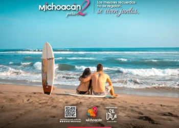 Pareja en la playa de Michoacán disfrutando del mar y la arena.
