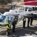 Helicóptero de emergencia con personal de rescate y ambulancia en escena.