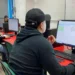 Aprendizaje en aula de informática con estudiantes usando computadoras y software de gestión.