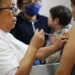 Vacunación contra COVID-19 en un centro de salud con personal médico y pacientes presentes.