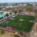 Cancha de fútbol 7 en Michoacán con jugadores y espectadores en un evento comunitario.