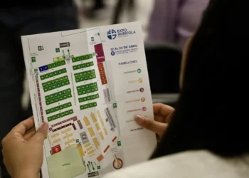 Persona sosteniendo un mapa del evento Expo Agrícola 2026, mostrando la distribución de expositores y pabellones en la feria.