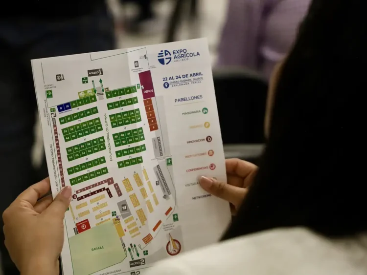 Persona sosteniendo un mapa del evento Expo Agrícola 2026, mostrando la distribución de expositores y pabellones en la feria.