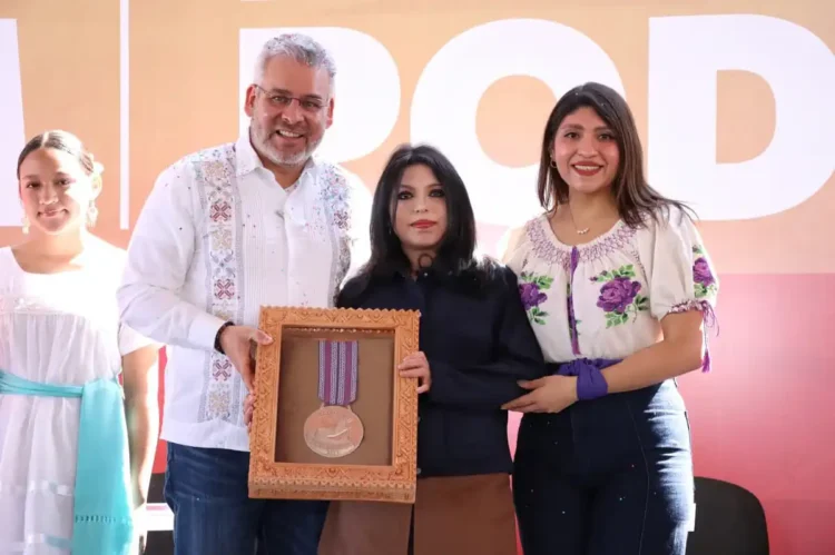 Joven michoacana posa con el premio Presea Eréndira en reconocimiento a su talento en física, acompañada por autoridades en u.