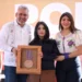 Joven michoacana posa con el premio Presea Eréndira en reconocimiento a su talento en física, acompañada por autoridades en u.