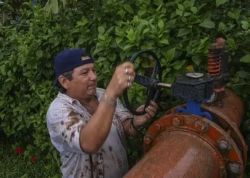 Técnico revisa válvula de un sistema de riego en un campo agrícola de Michoacán.