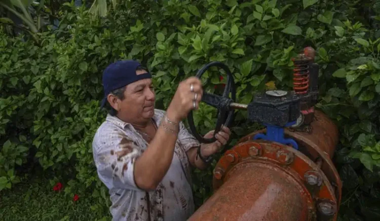 Técnico revisa válvula de un sistema de riego en un campo agrícola de Michoacán.