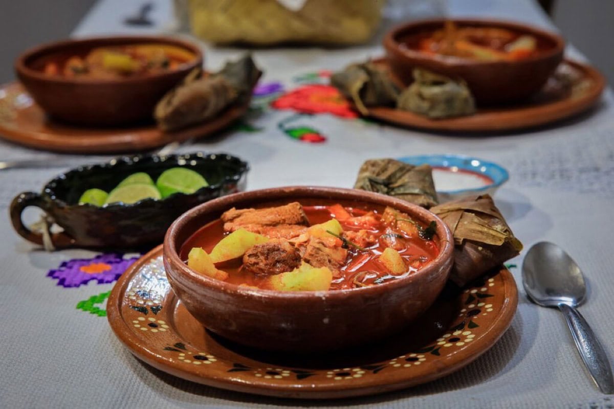 Tazones de caldo de res con verduras y tortillas de maíz en un ambiente tradicional michoacano.