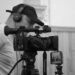 Cámara profesional de cine con operador ajustando el enfoque en un set de grabación.