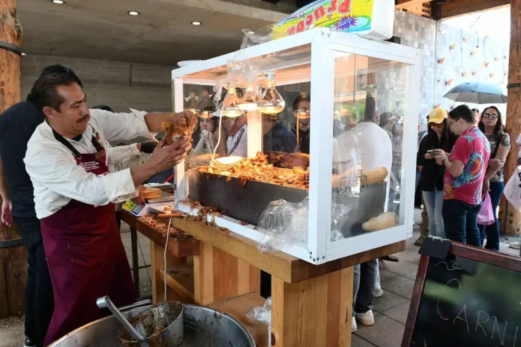 Carne asada en puesto callejero durante evento en Michoacán con público disfrutando.