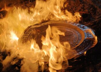 Manhole cover burning amidst flames, symbolizing cultural resilience and social issues in Michoacán.