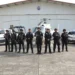 Personal de Guardia Civil en Michoacán posando con vehículos y helicóptero en un hangar.