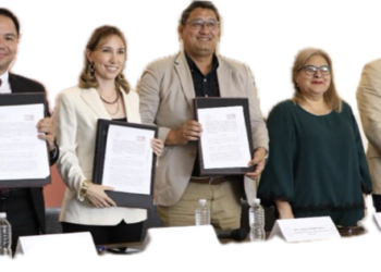 Personas sosteniendo documentos en una conferencia oficial.