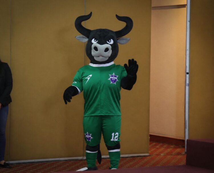 Mascota de equipo de fútbol con disfraz de toro en evento internacional de policías y bomberos en Michoacán.