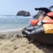 Moto acuática en playa con olas y rocas en el fondo, personal de rescate en acción en Michoacán.